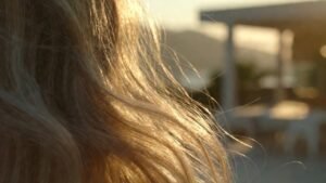 Mulher loira com cabelo brilhante e saudável em um ambiente de spa luxuoso em Balneário Camboriú, luz solar suave de fim de tarde, estética minimalista tons bege e dourado.