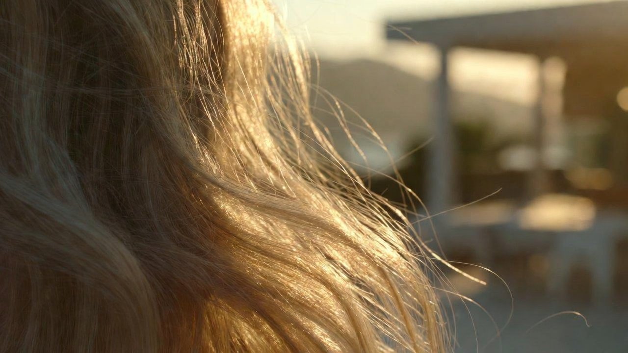 Mulher loira com cabelo brilhante e saudável em um ambiente de spa luxuoso em Balneário Camboriú, luz solar suave de fim de tarde, estética minimalista tons bege e dourado.